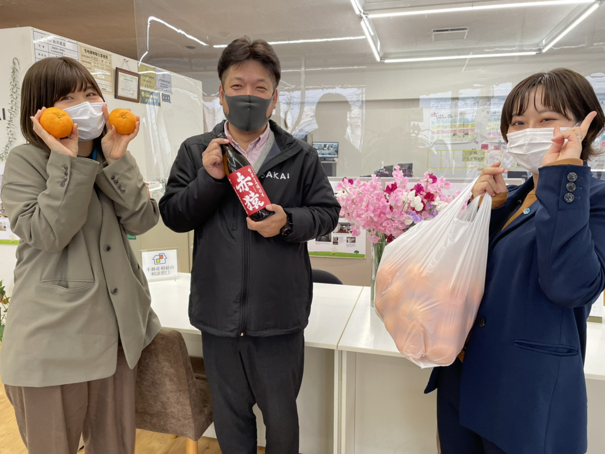 津久見のSAKAIファミリーのお客様よりいただいたみかんとスタッフ