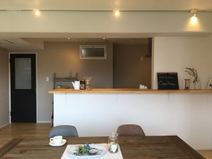 ライティングレールがキッチンカウンター上部に通っているリビングの写真